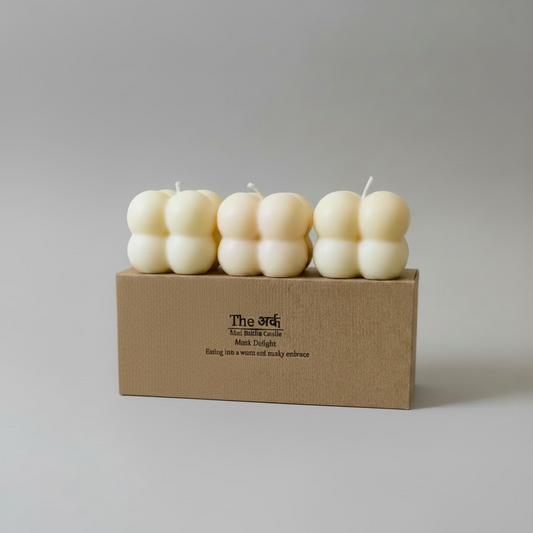 Set of colorful candles in a box with a red ribbon on a white background