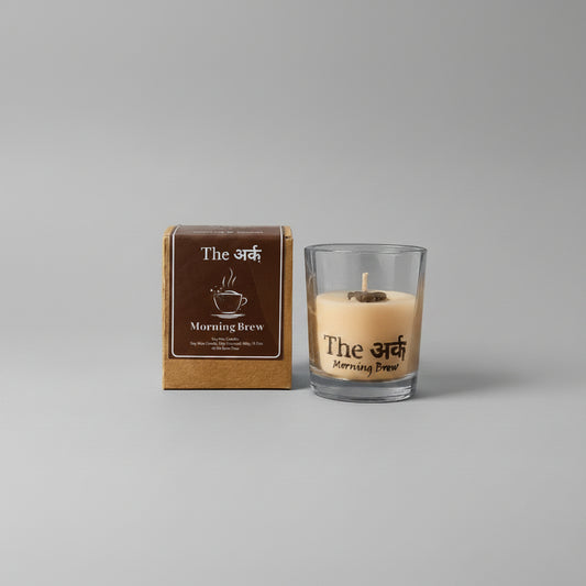 Glass candle and packaging labeled 'The Morning Brew' on an orange background